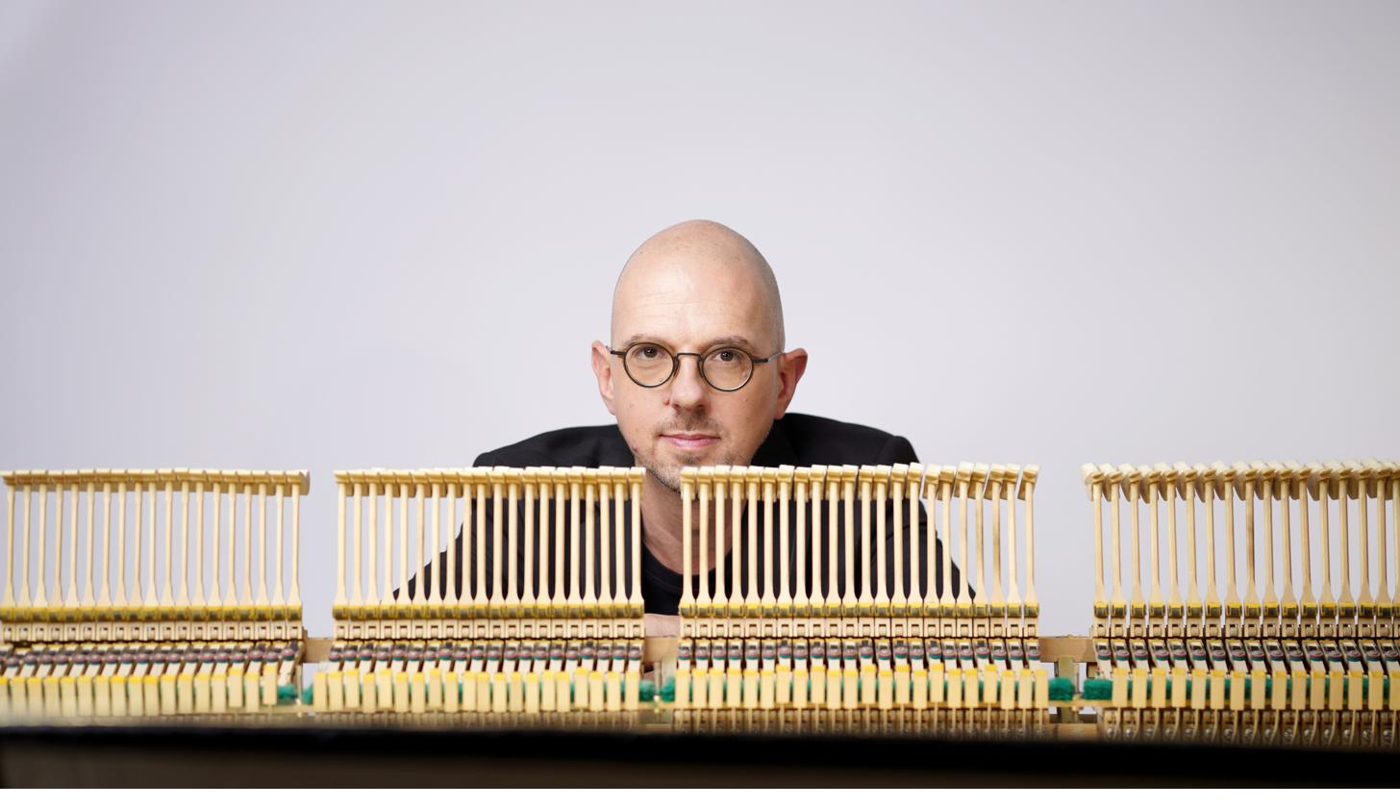 Michaël Ertzscheid derrière la mécanique d'un piano, marteaux levés